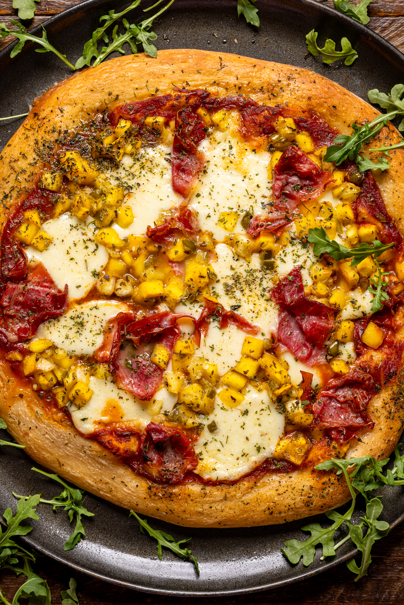 Image of baked Hawaiian pizza with greens.
