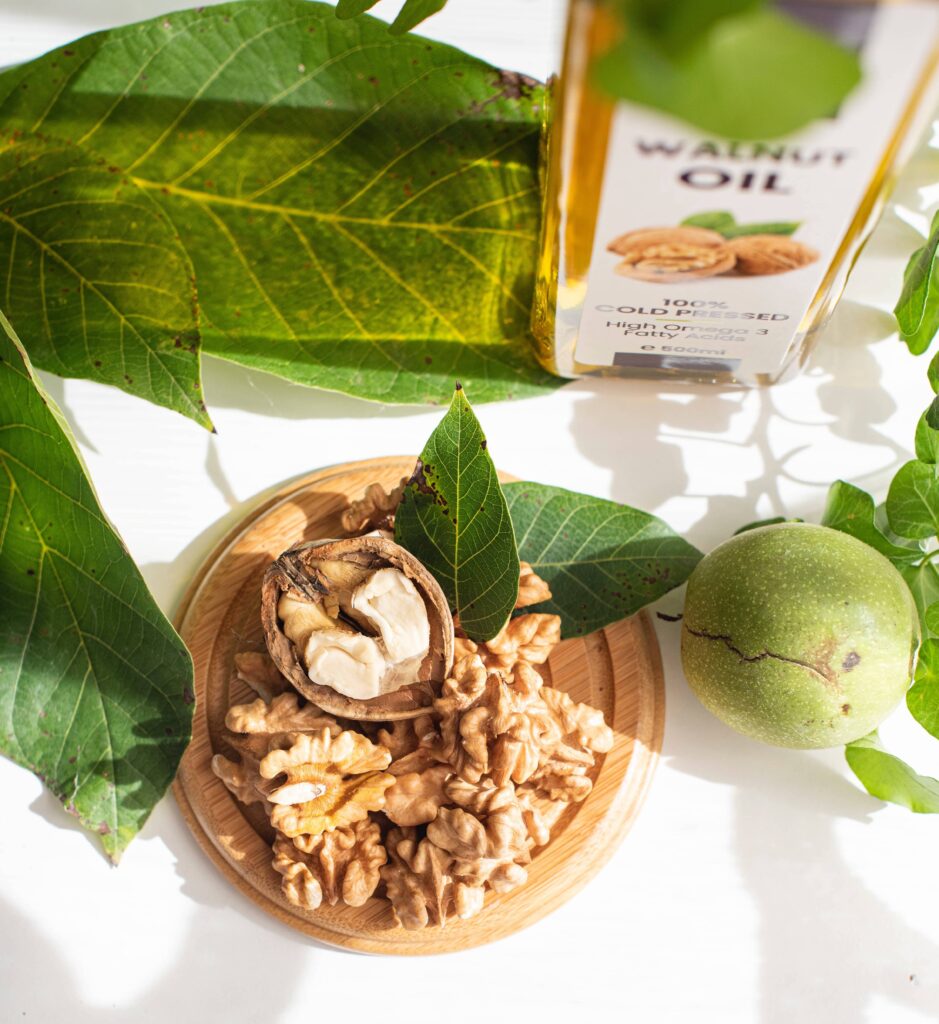 Bowl of walnuts next to a jar of walnut oil.