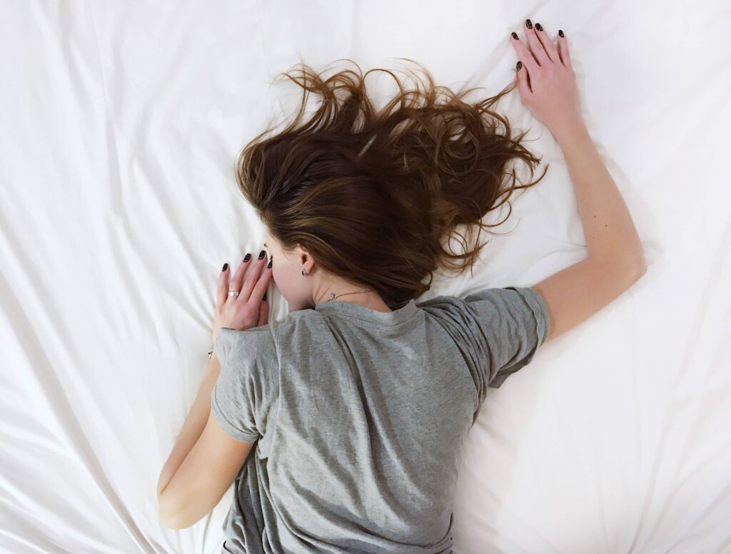 Woman lying on her stomach on a white sheet