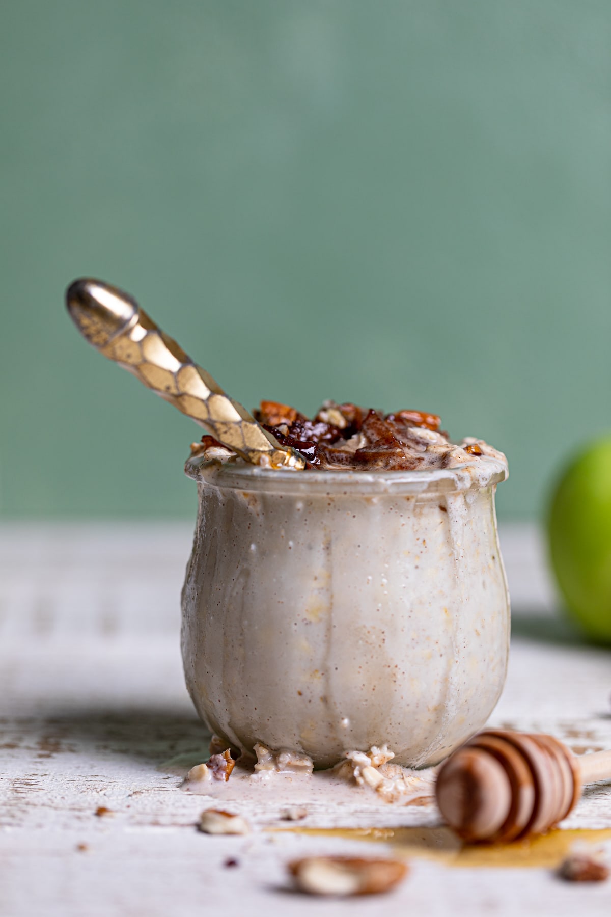 Golden spoon in a glass of Apple Pie Overnight Oats.