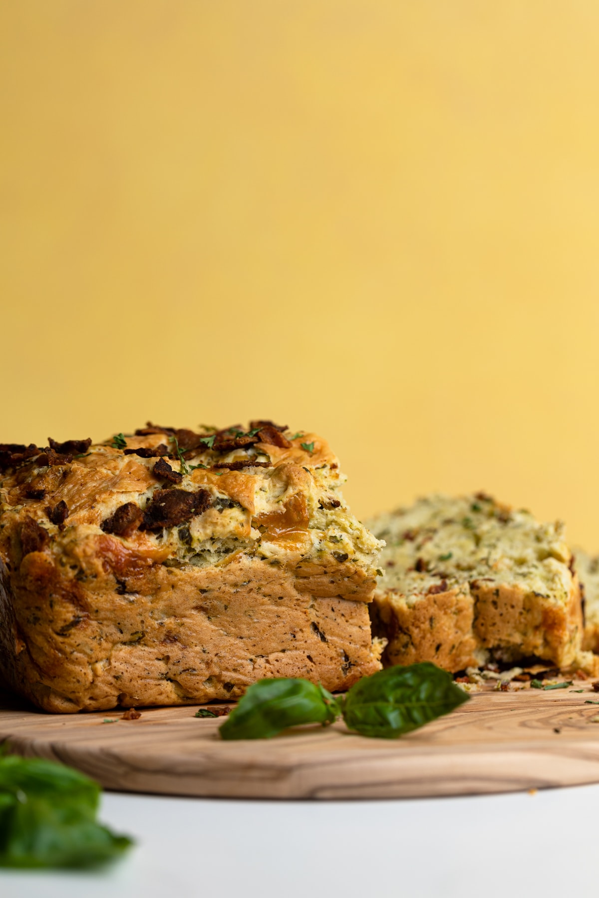 Partially-sliced Loaded Cheddar Pesto Zucchini Bread with Bacon.