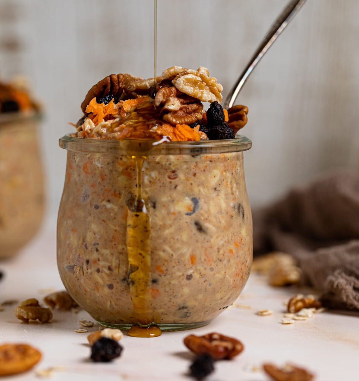 Spiced Carrot Cake Overnight Oats being drizzled with maple syrup