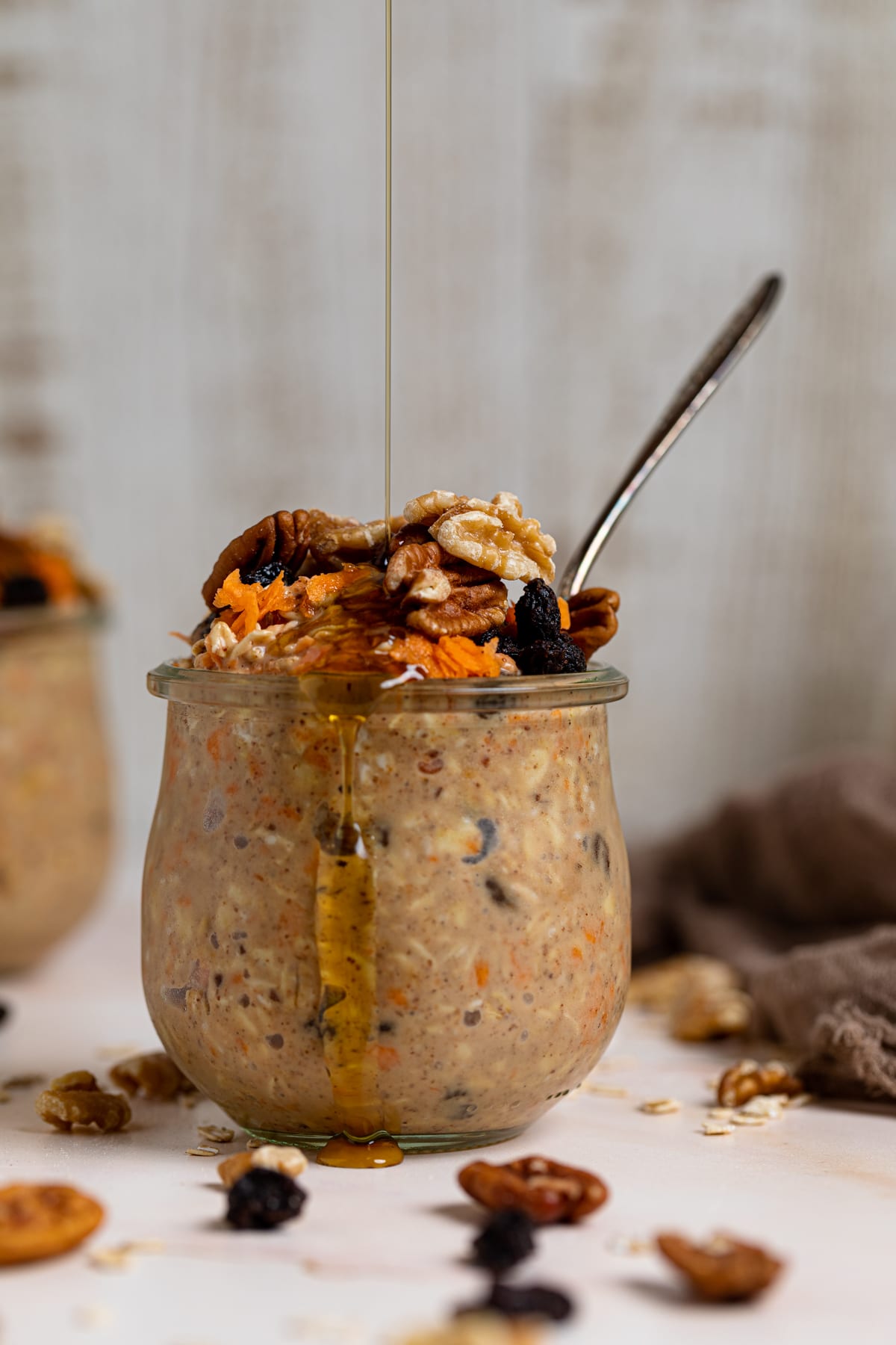 Spiced Carrot Cake Overnight Oats being drizzled with maple syrup