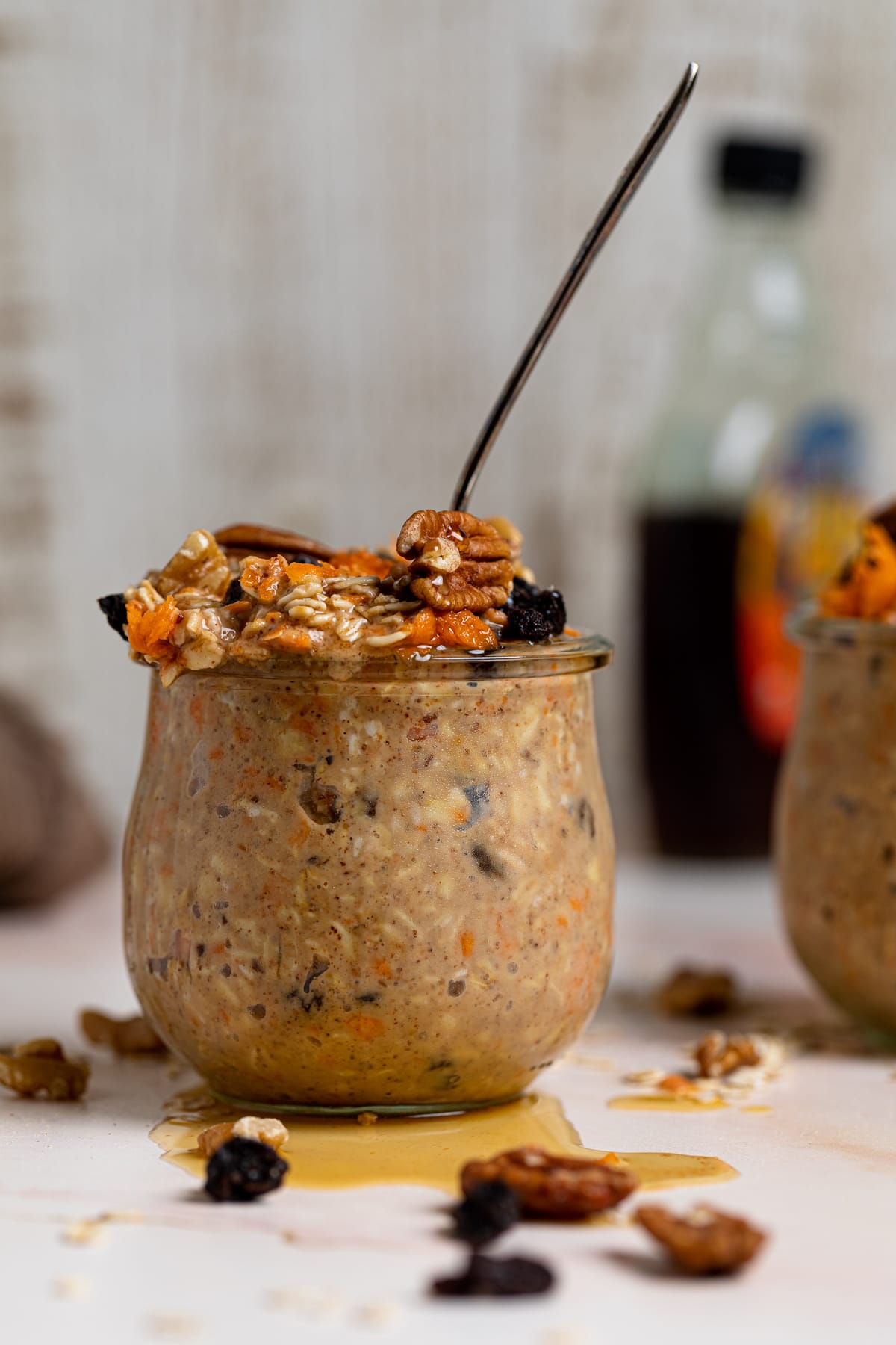 Glass of Spiced Carrot Cake Overnight Oats with a spoon