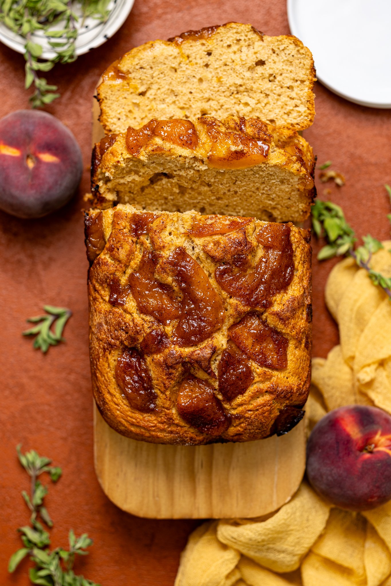 Baked Easy Homemade Cinnamon Peach Bread sliced on a wood platter.