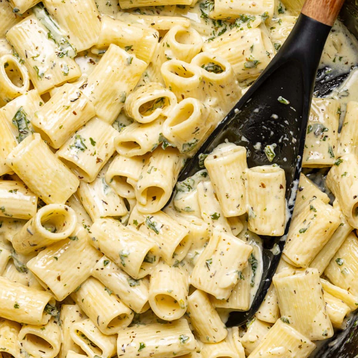 Deep black skillet filled with creamy pasta.