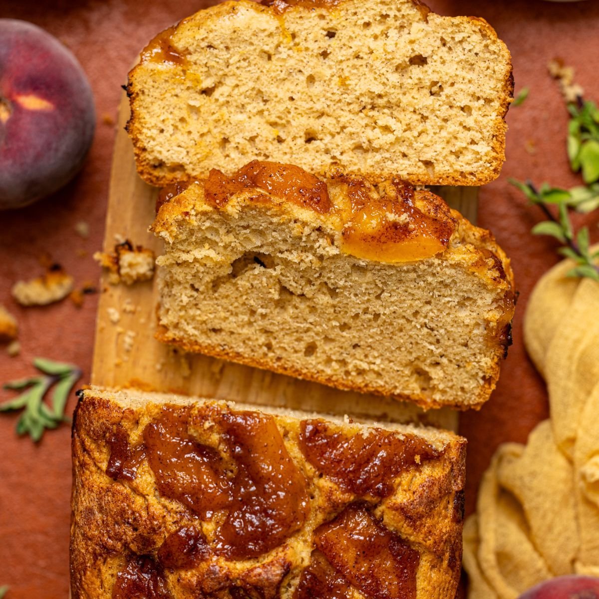 Baked Easy Homemade Cinnamon Peach Bread sliced on a wood platter.