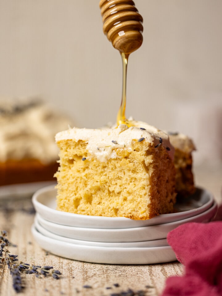 Honey drizzled on a slice of cake stacked on plates.