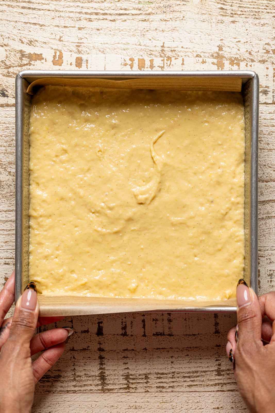 Cake batter in a square cake pan.