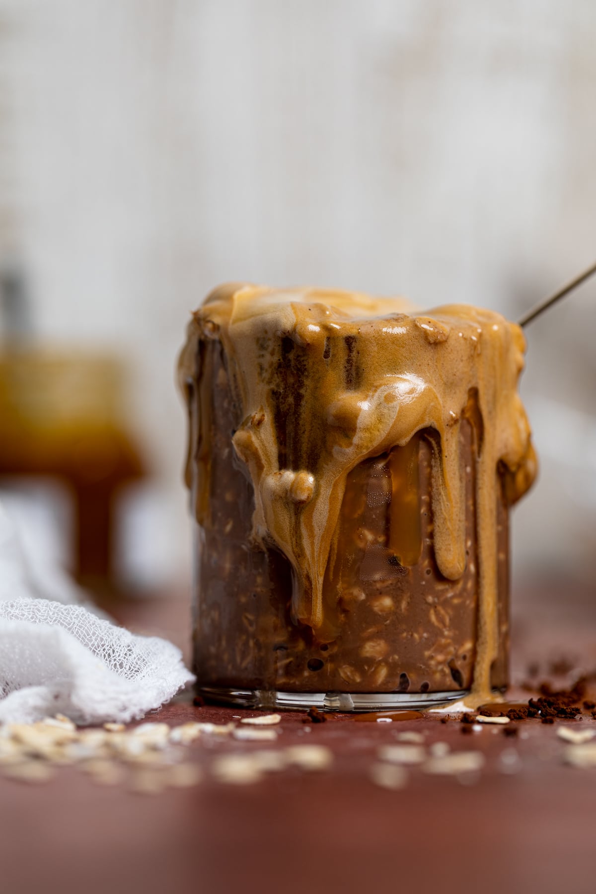 Overflowing glass of Caramel Mocha Overnight Oats with Whipped Coffee.