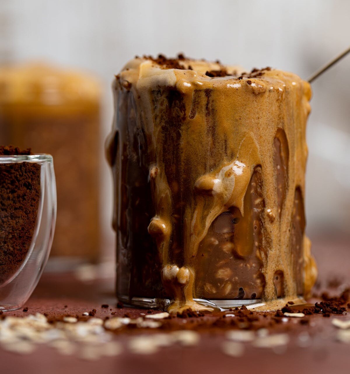 Overflowing glass of Caramel Mocha Overnight Oats with Whipped Coffee