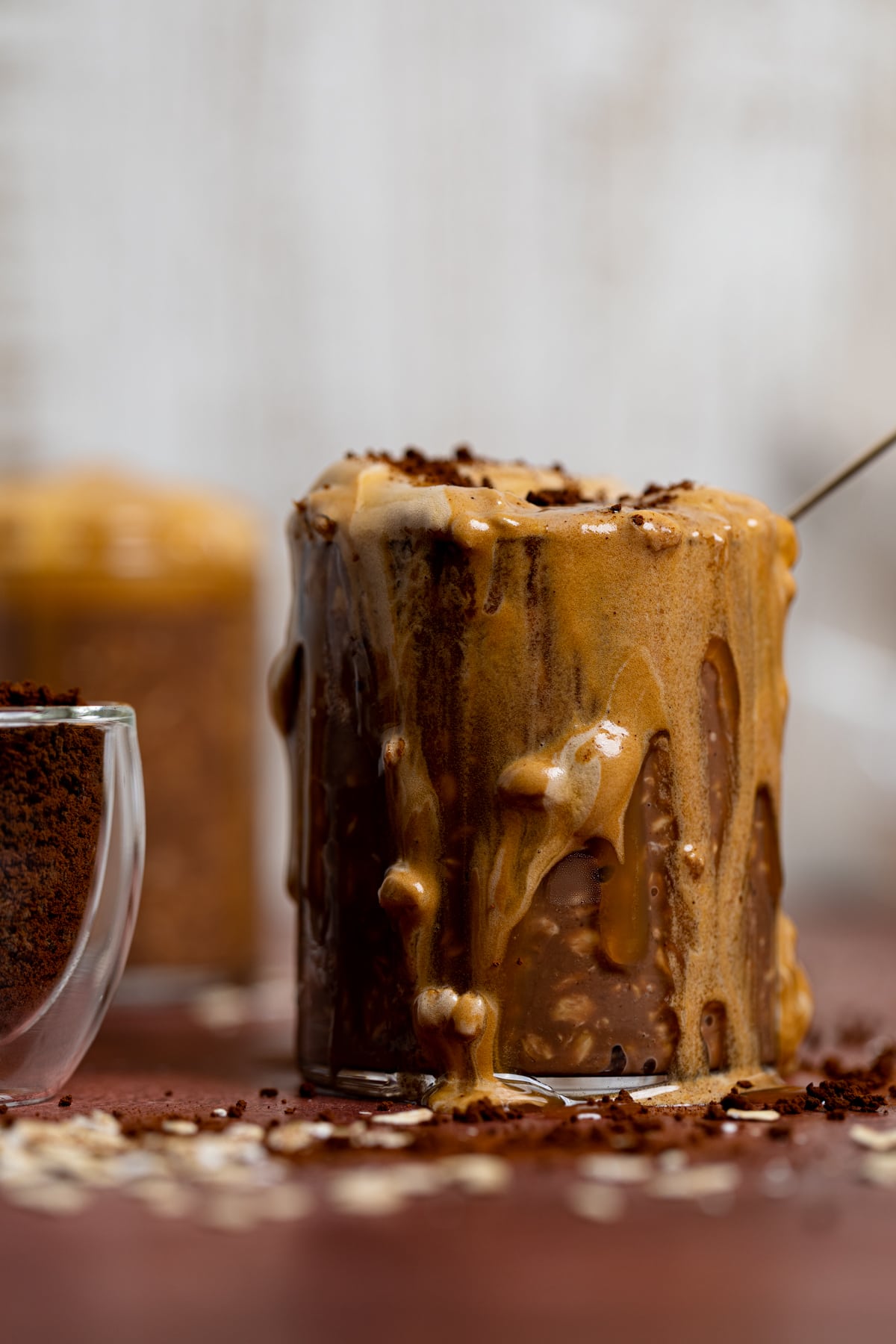 Overflowing glass of Caramel Mocha Overnight Oats with Whipped Coffee