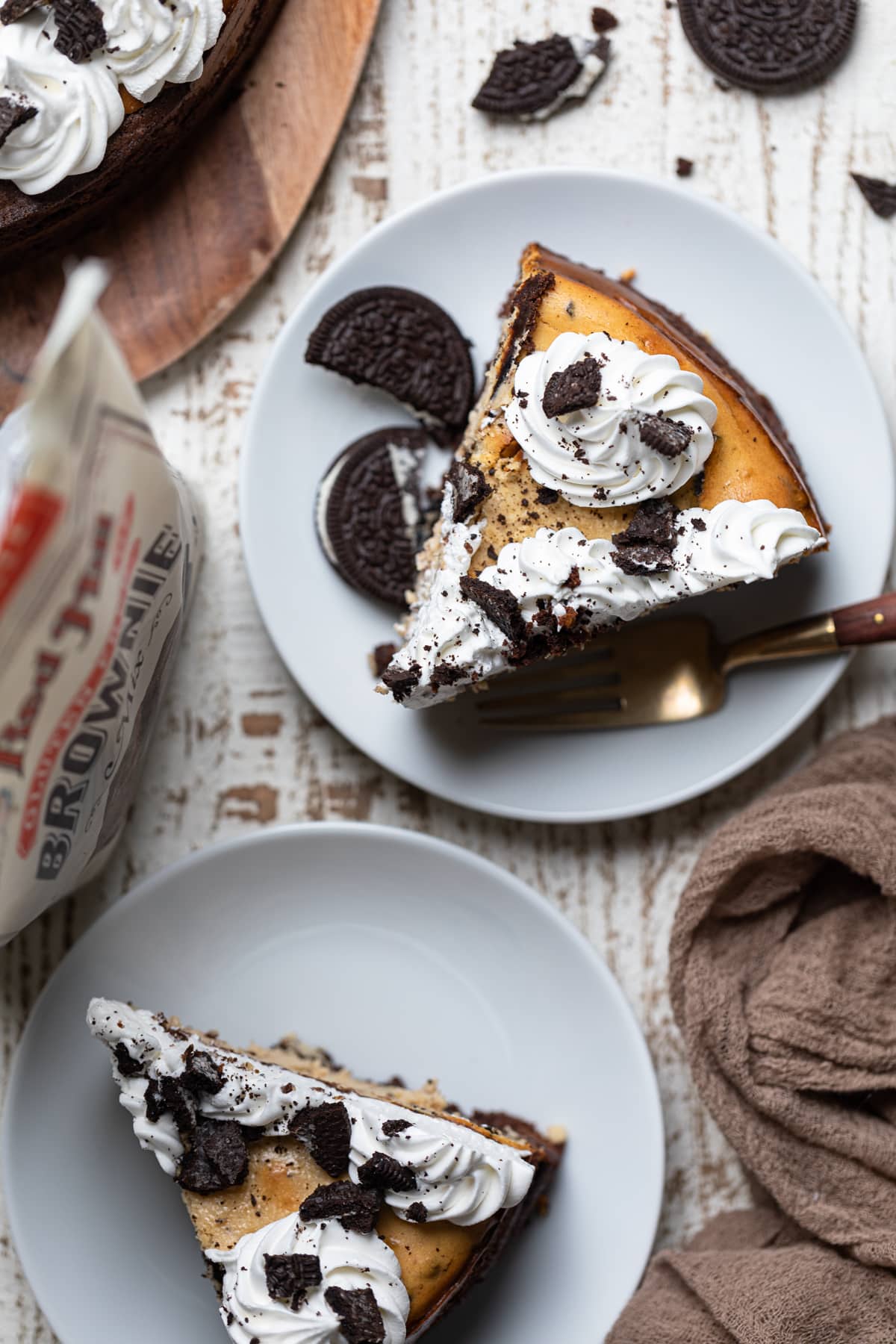 Slices of Gluten-Free Peanut Butter Cookies N\' Cream Brownie Cheesecake on plates