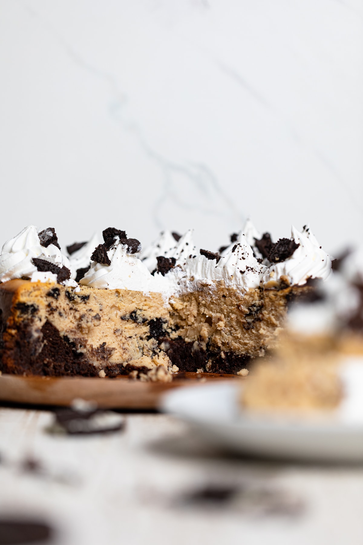 Gluten-Free Peanut Butter Cookies N\' Cream Brownie Cheesecake missing a slice