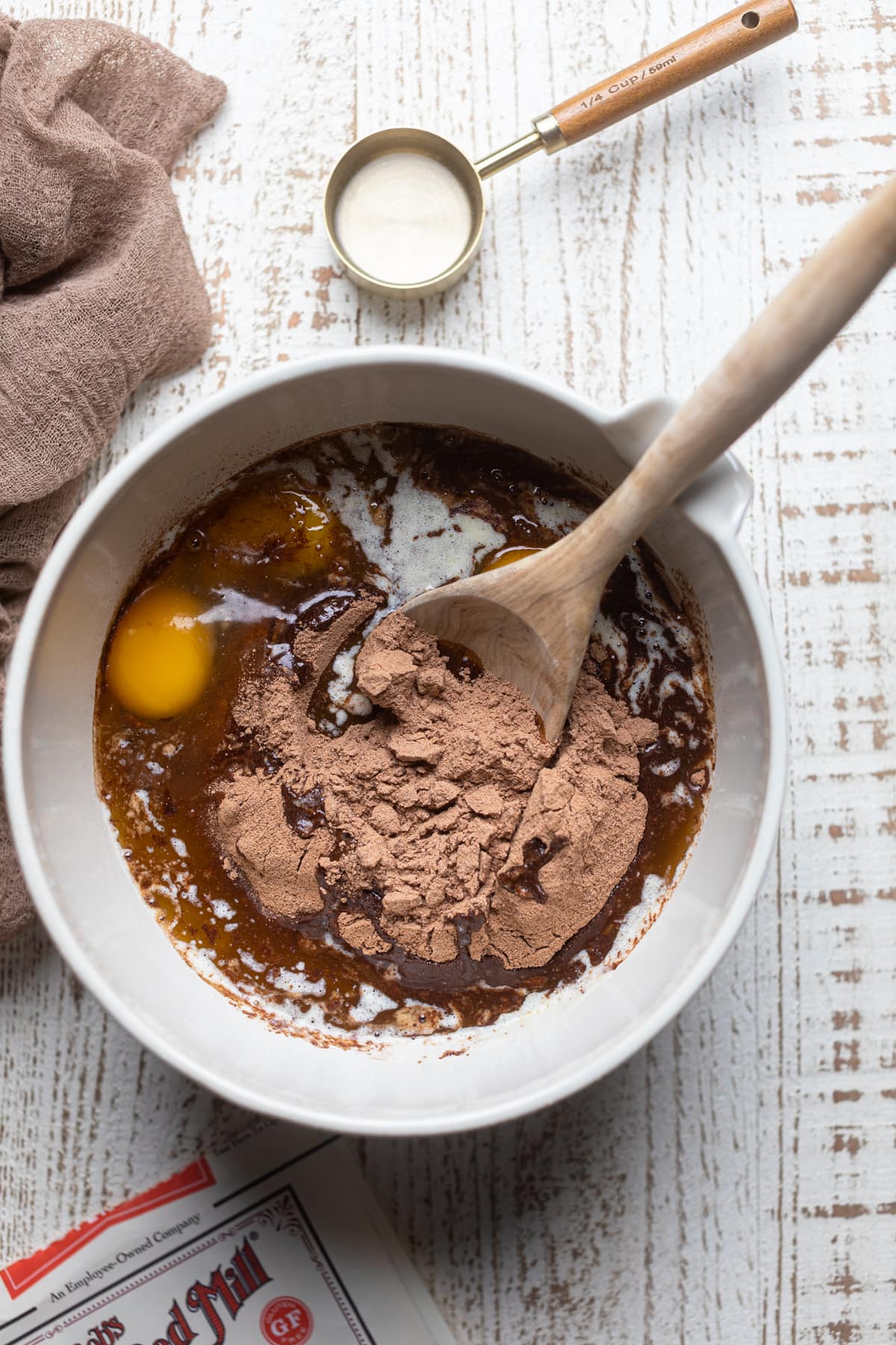 Gluten free brownie mix, eggs, and melted butter unmixed in a bowl