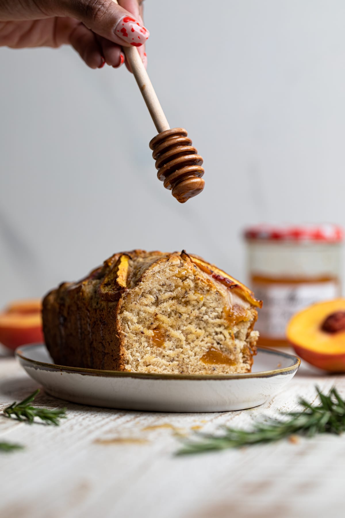 Honey dipper over a loaf of Cinnamon Maple Peach Bread 