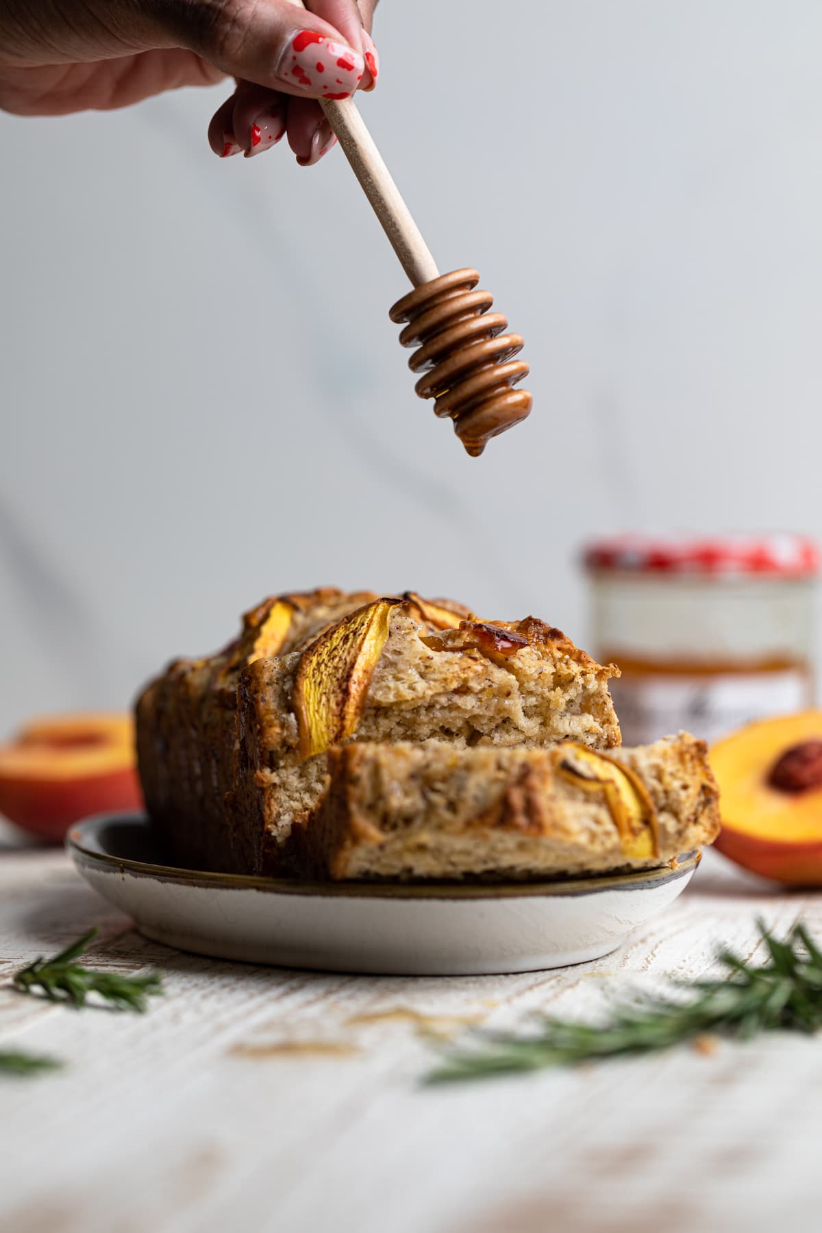 Honey dipper over a loaf of Cinnamon Maple Peach Bread 