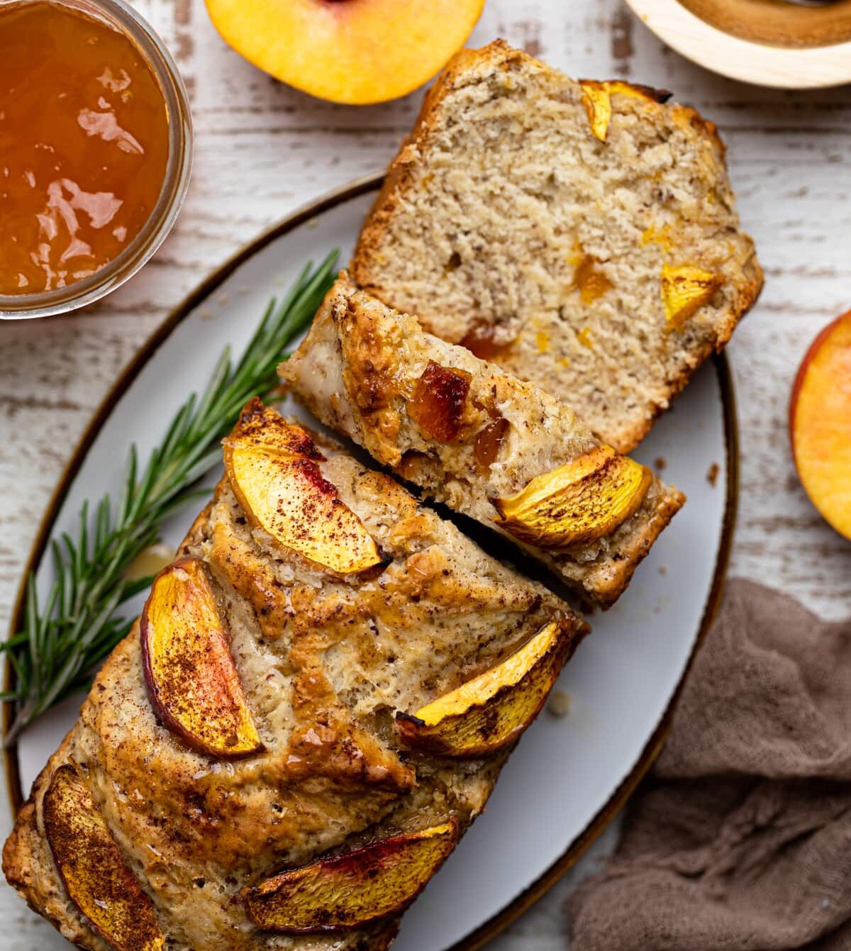 Partially sliced loaf of Cinnamon Maple Peach Bread on a platter