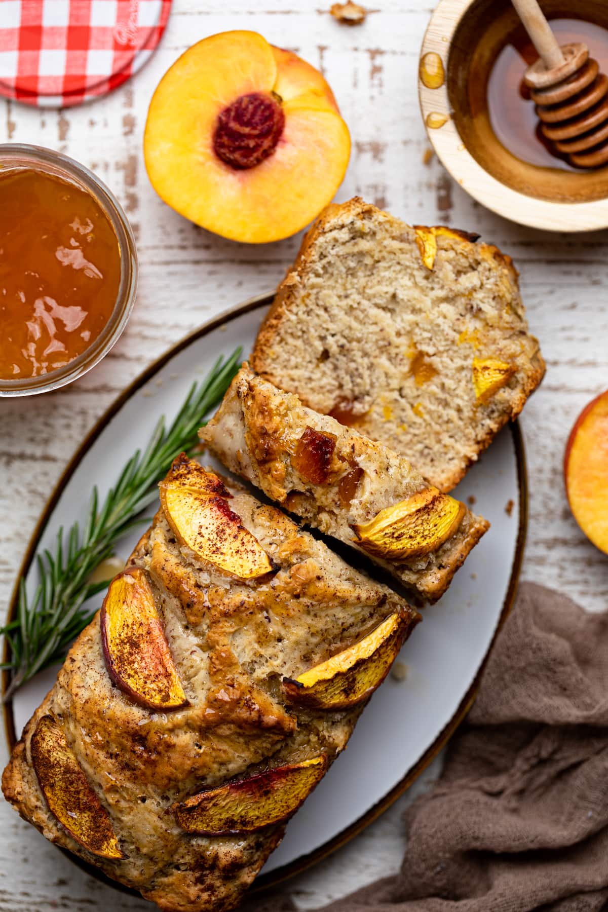 Partially sliced loaf of Cinnamon Maple Peach Bread on a platter