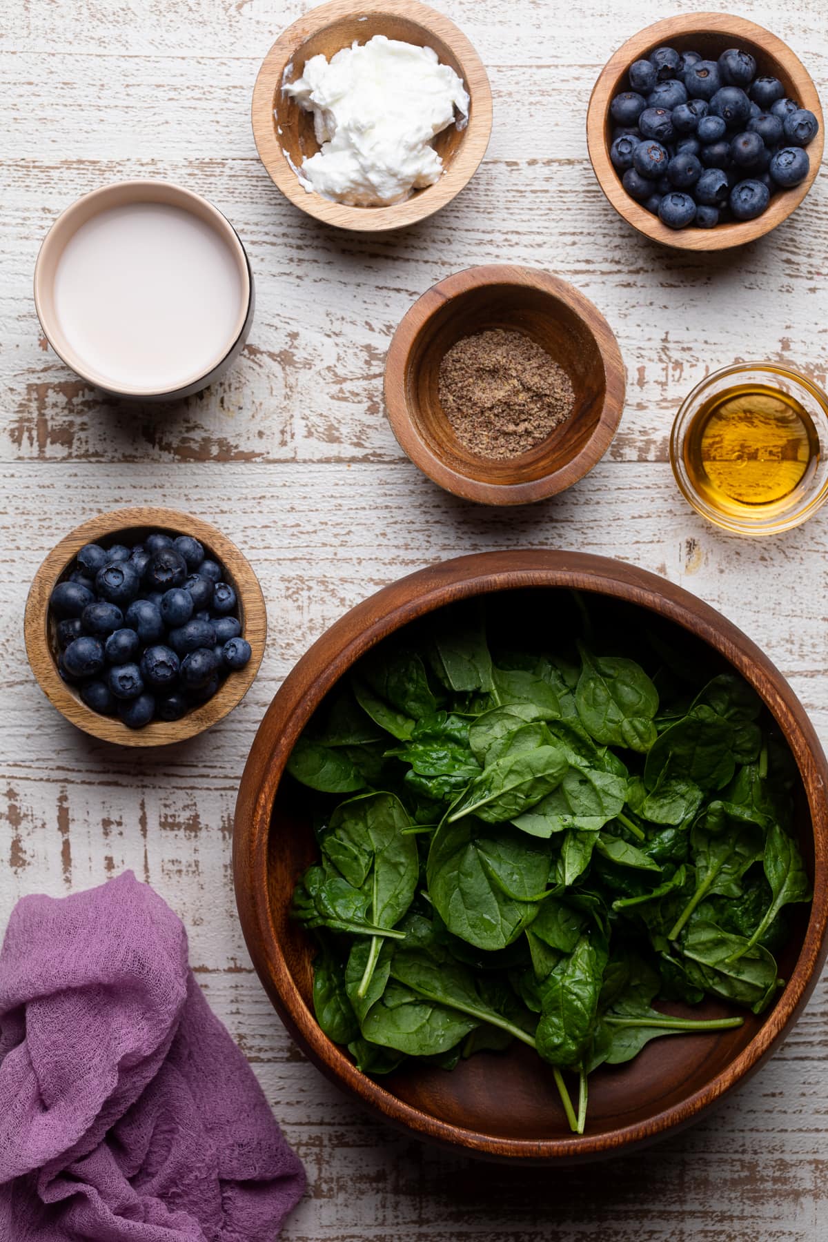 Ingredients for a Spinach Blueberry Smoothie including almond milk, agave, and dairy-free yogurt