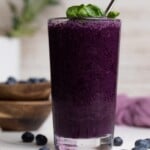 Spinach Blueberry Smoothie in a tall glass with a metal spoon