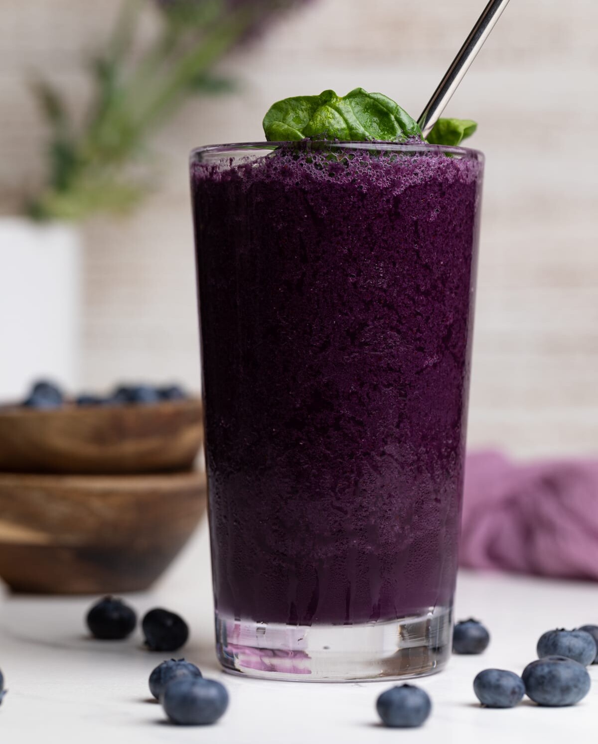 Spinach Blueberry Smoothie in a tall glass with a metal spoon