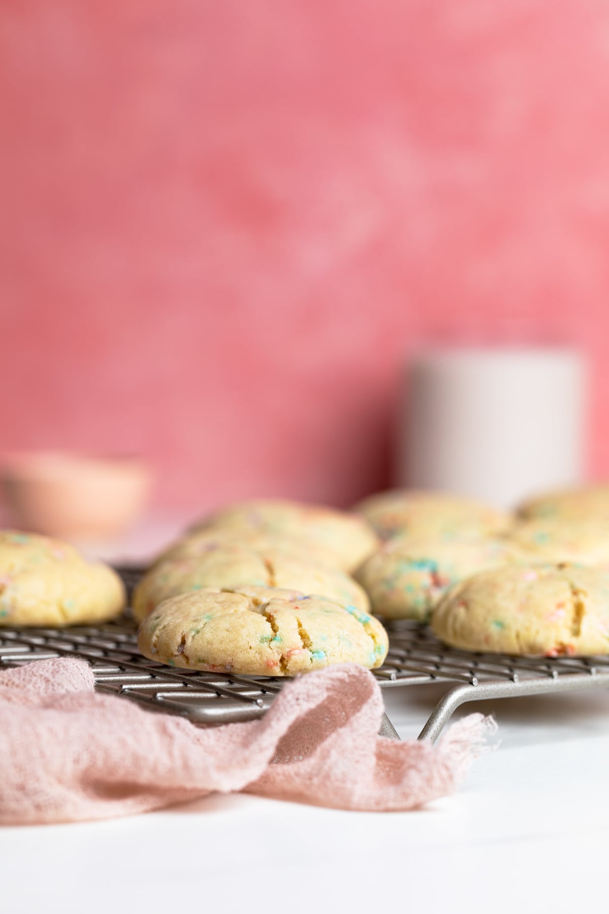 Side view of Thick and Chewy Funfetti Cookies on a wire rack
