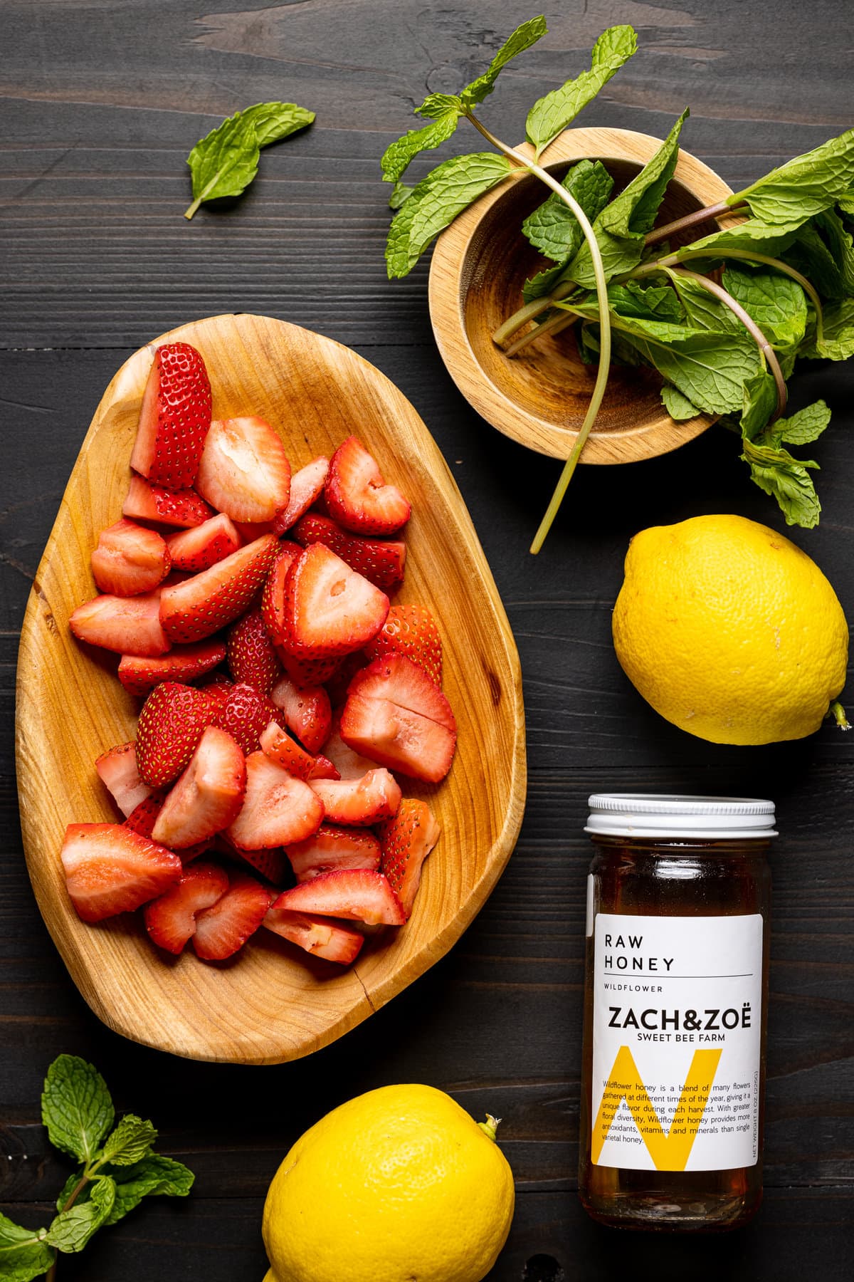 Ingredients for Roasted Dandelion Strawberry Tea including strawberries, lemon, and raw honey