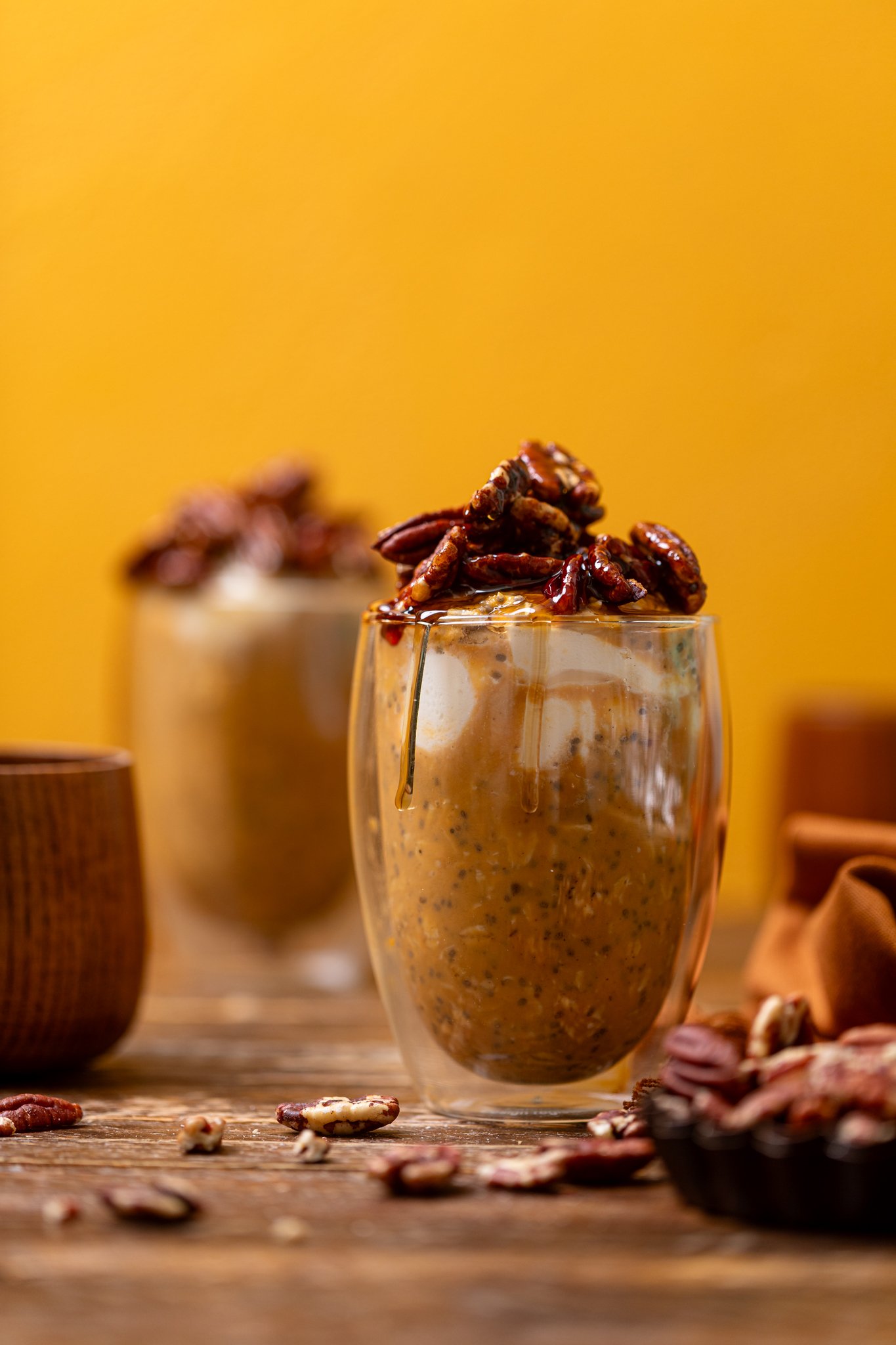Sweet Potato Pie Overnight Oats in two glasses with pecans.