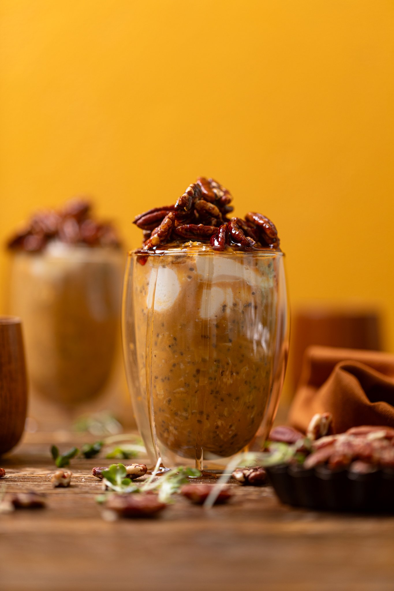 Sweet Potato Pie Overnight Oats in two glasses on brown wood table.