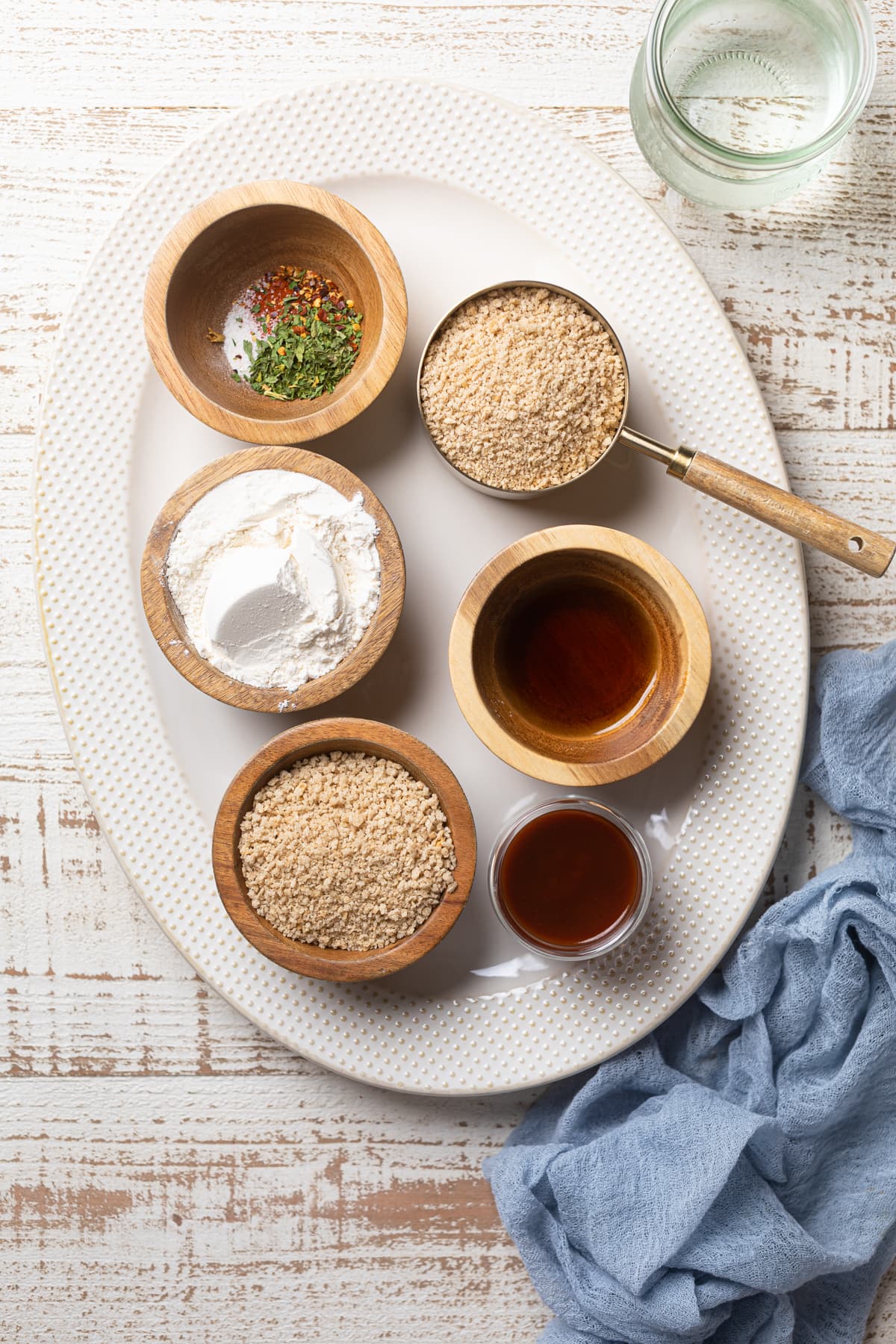 Ingredients on a platter including gluten-free flour, honey, and red pepper flakes