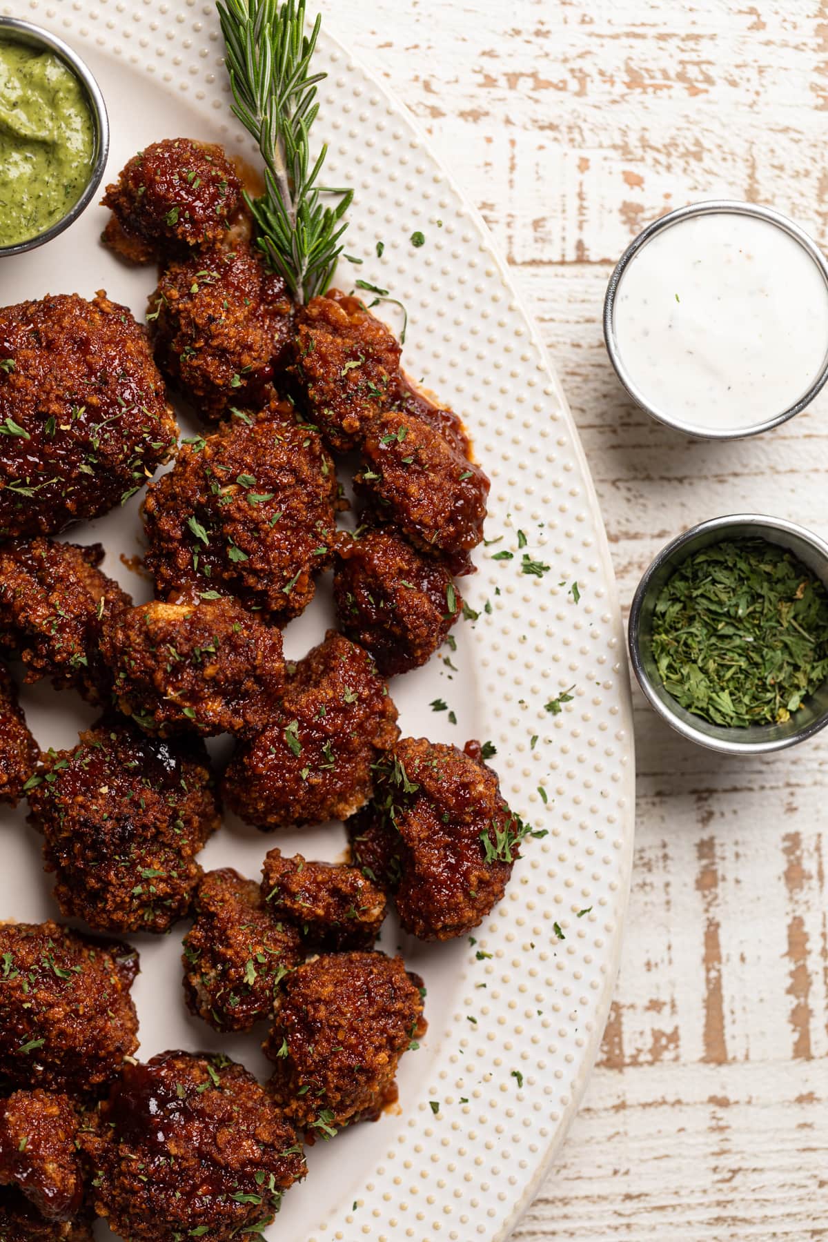 Platter of barbeque Cauliflower Wings with small bowls of dips