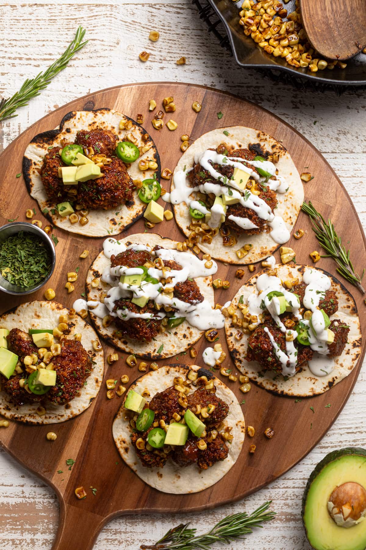 Barbeque Cauliflower Tacos topped with white dressing, jalapeno slices, and avocado