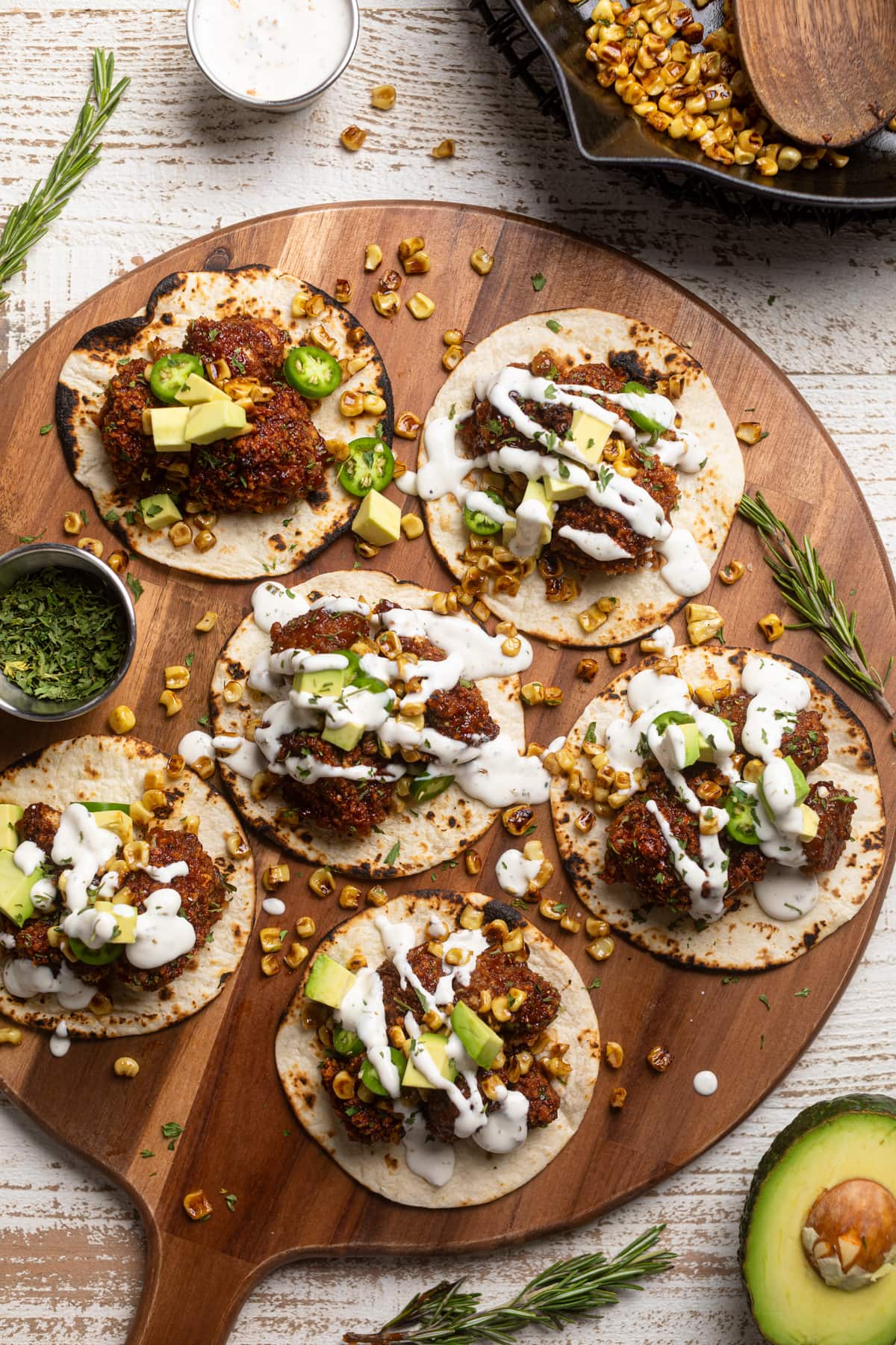 Barbeque Cauliflower Tacos drizzled with white dressing and on a wooden board