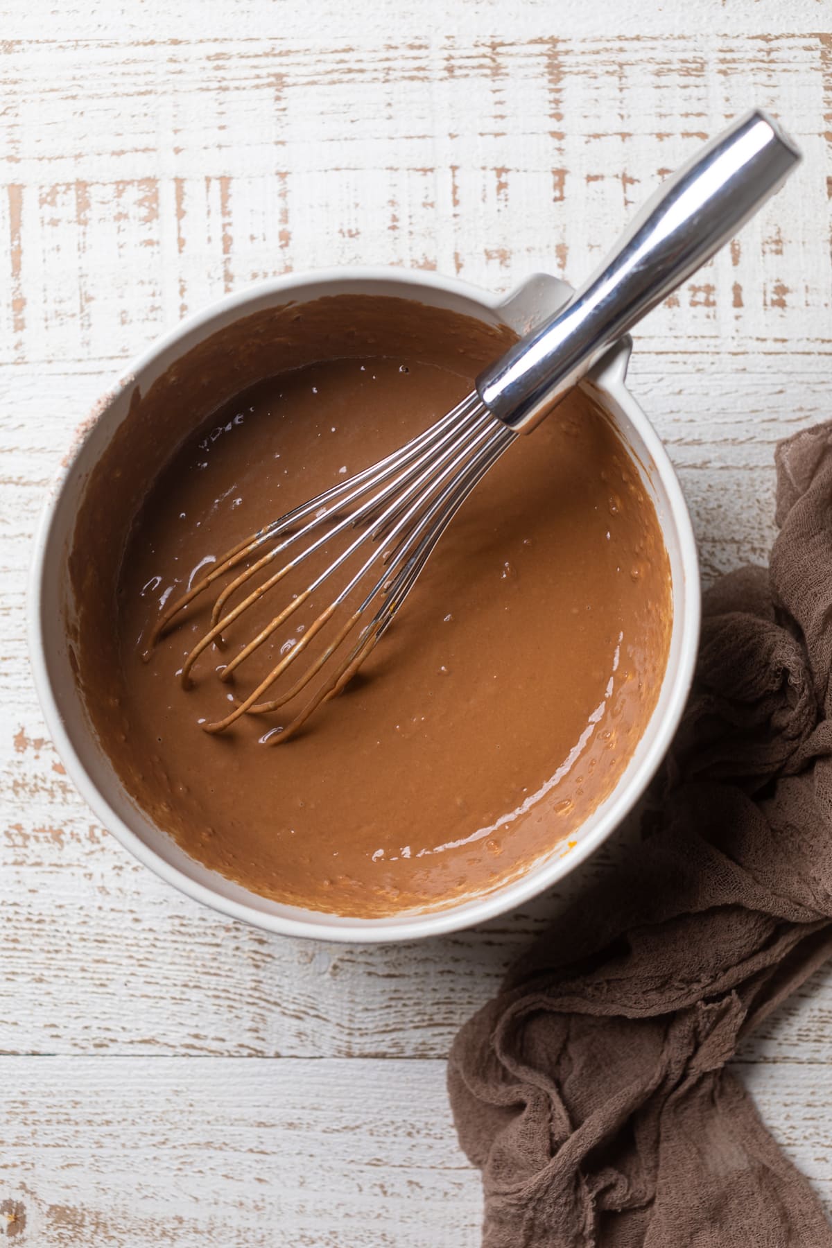 Whisk in a bowl of chocolate glaze