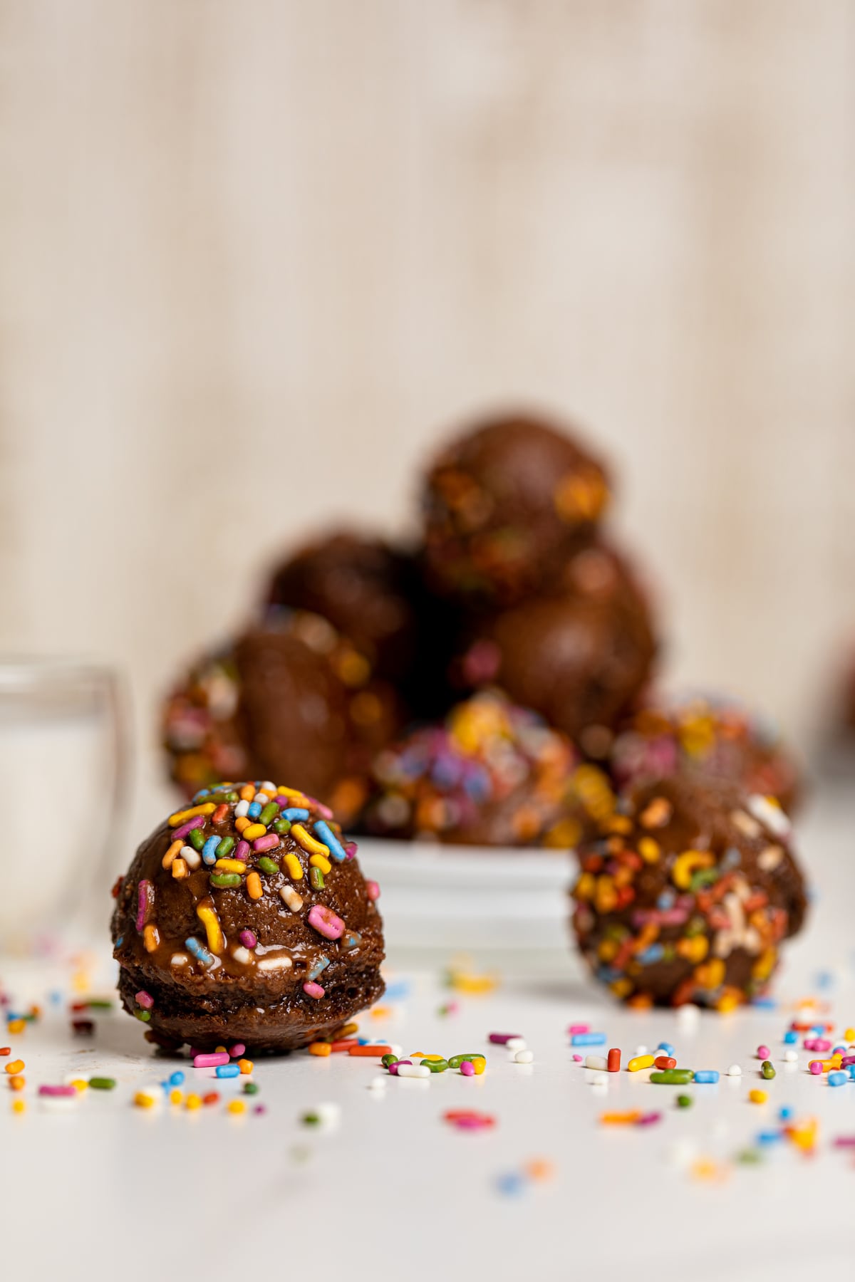 Vegan Chocolate Donut Holes on a white table and white plates