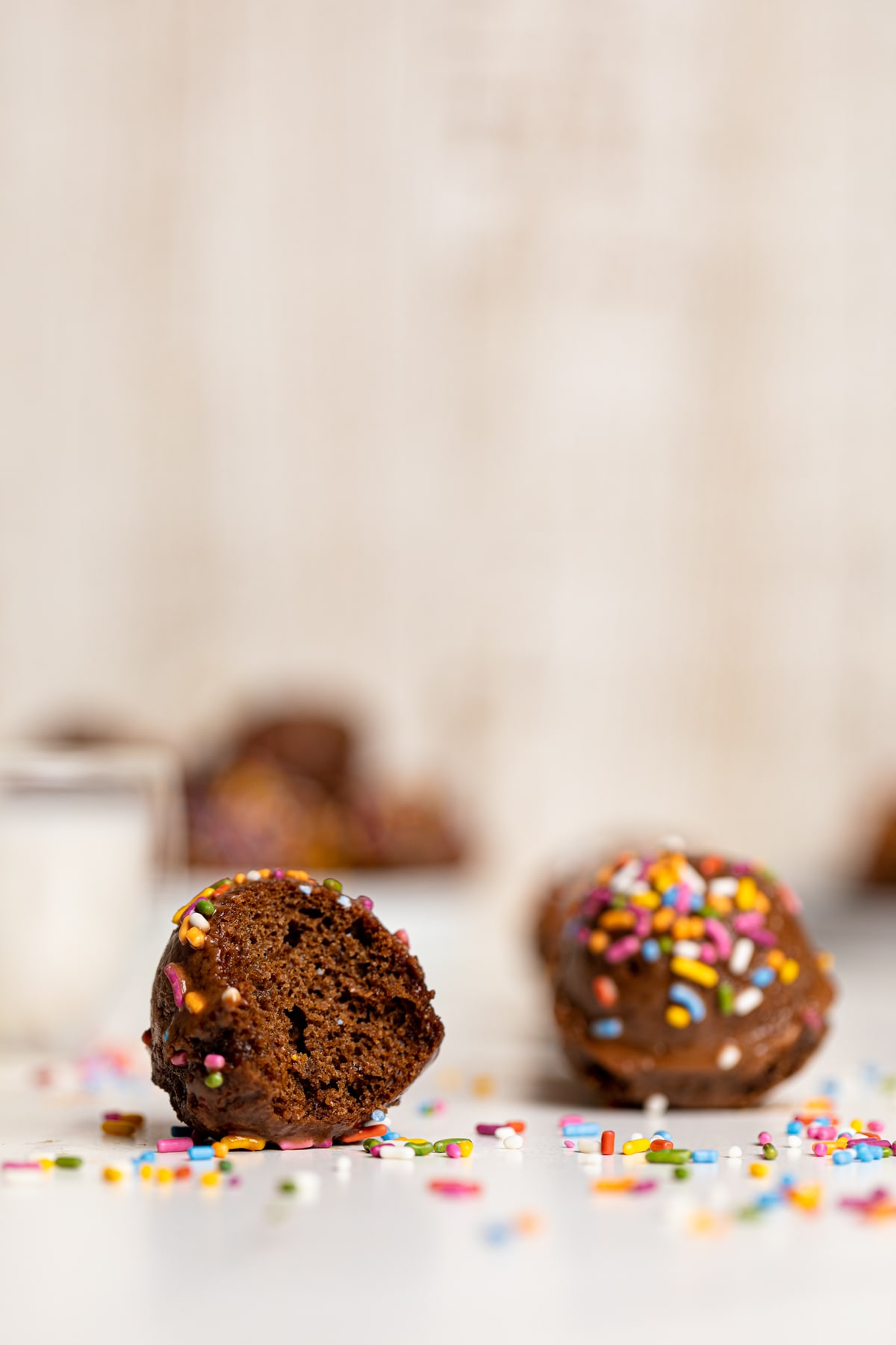 Half-eaten Vegan Chocolate Donut Hole on a white table