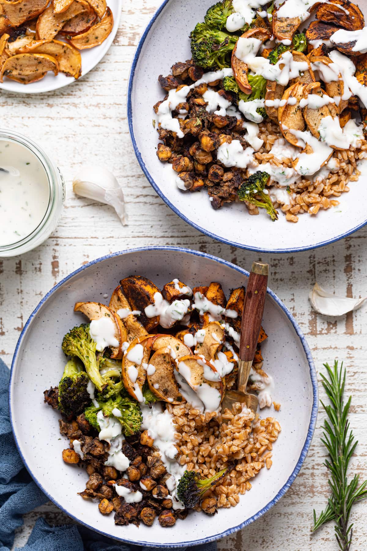 Two Jerk Vegetable Farro Bowls drizzled with dairy-free garlic dressing