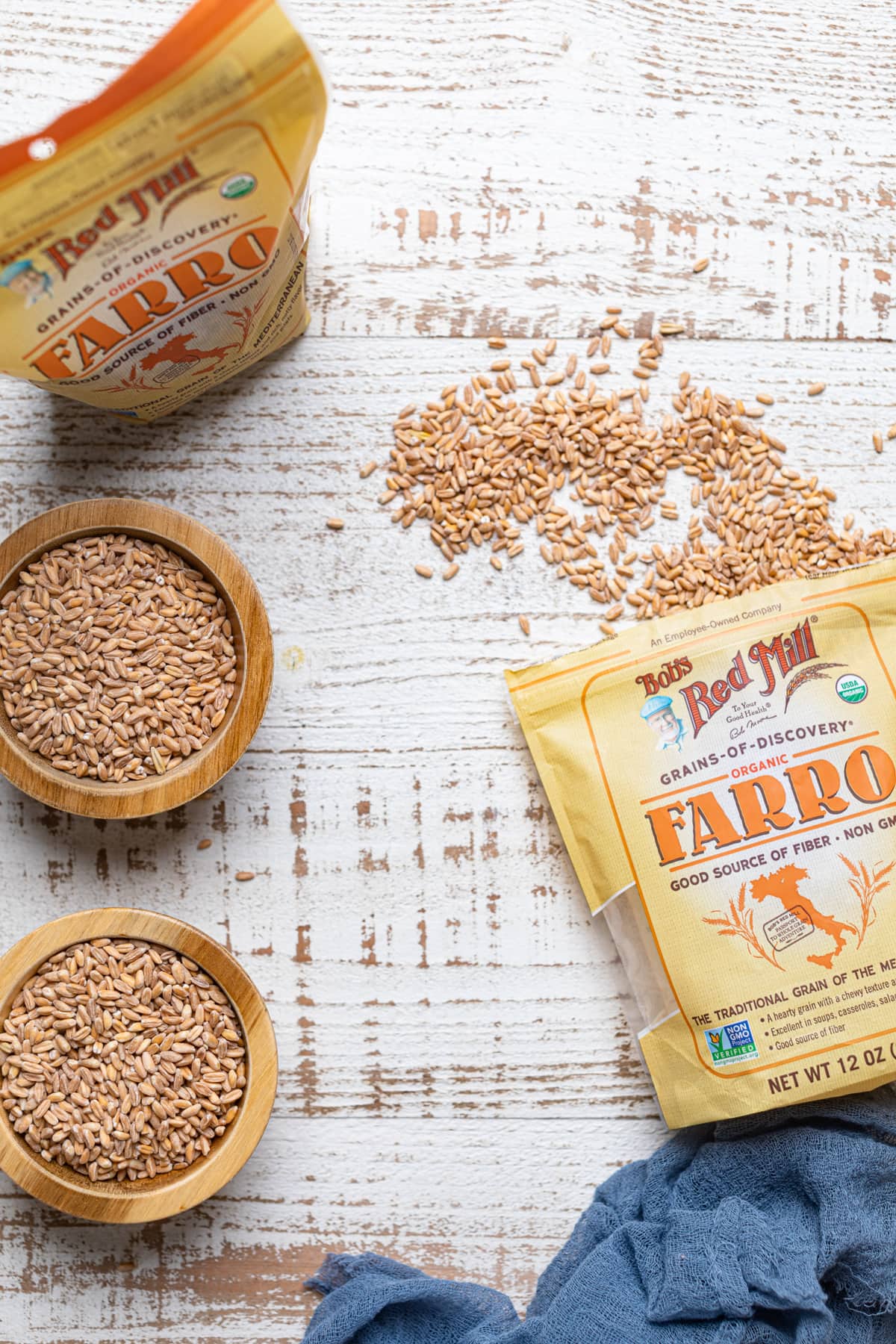 Bowls and bags of farro on a white table