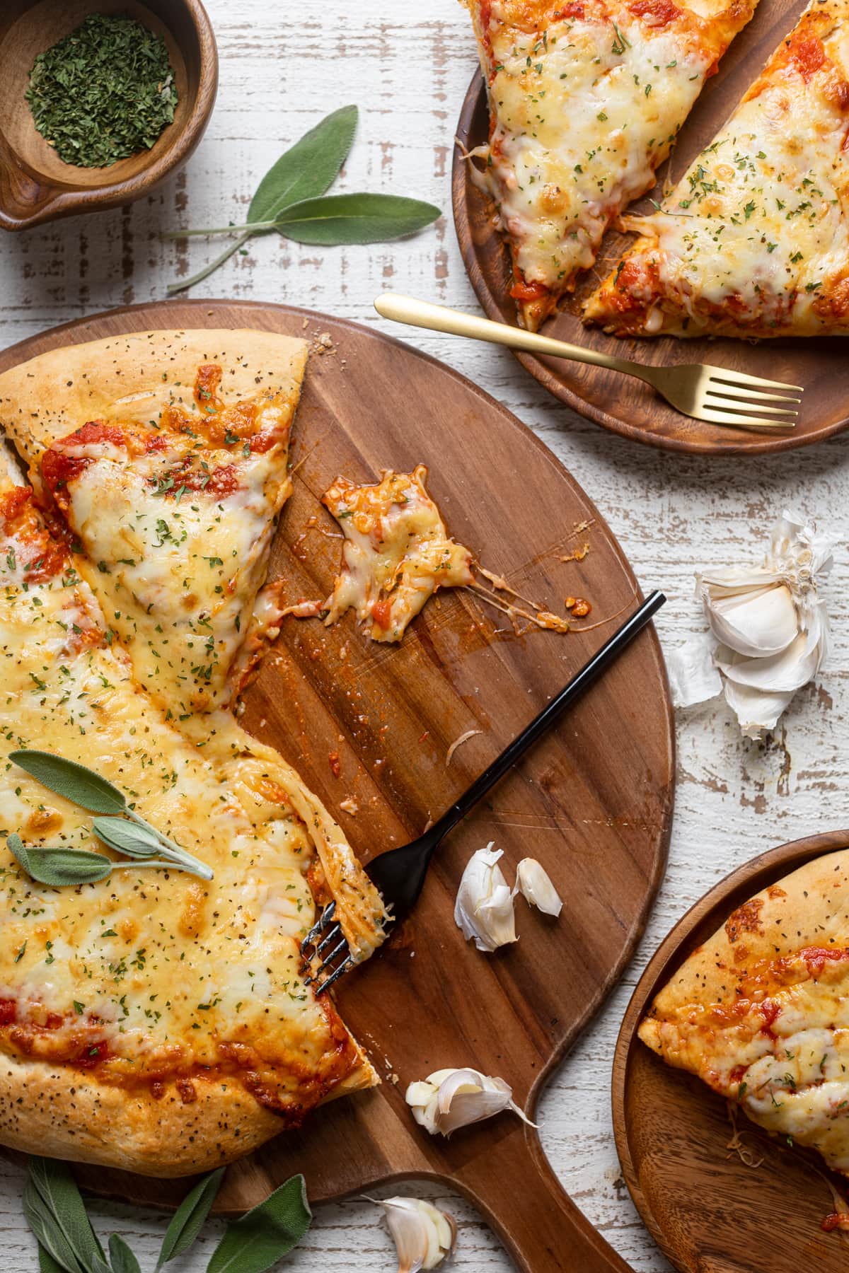 Plates and a wooden board of Garlic Herb Cheese Pizza 