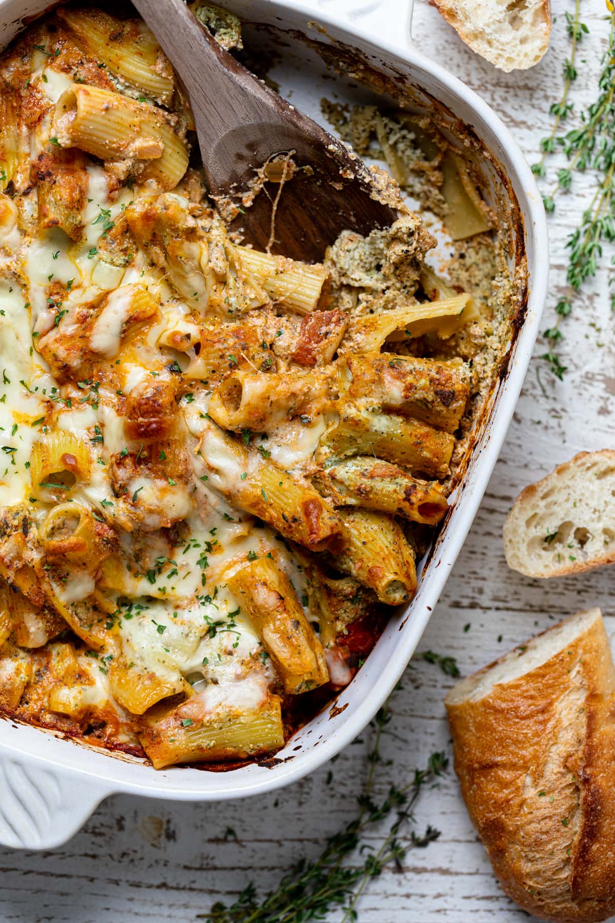 Wooden spoon scooping Pesto Pasta Bake with Ricotta