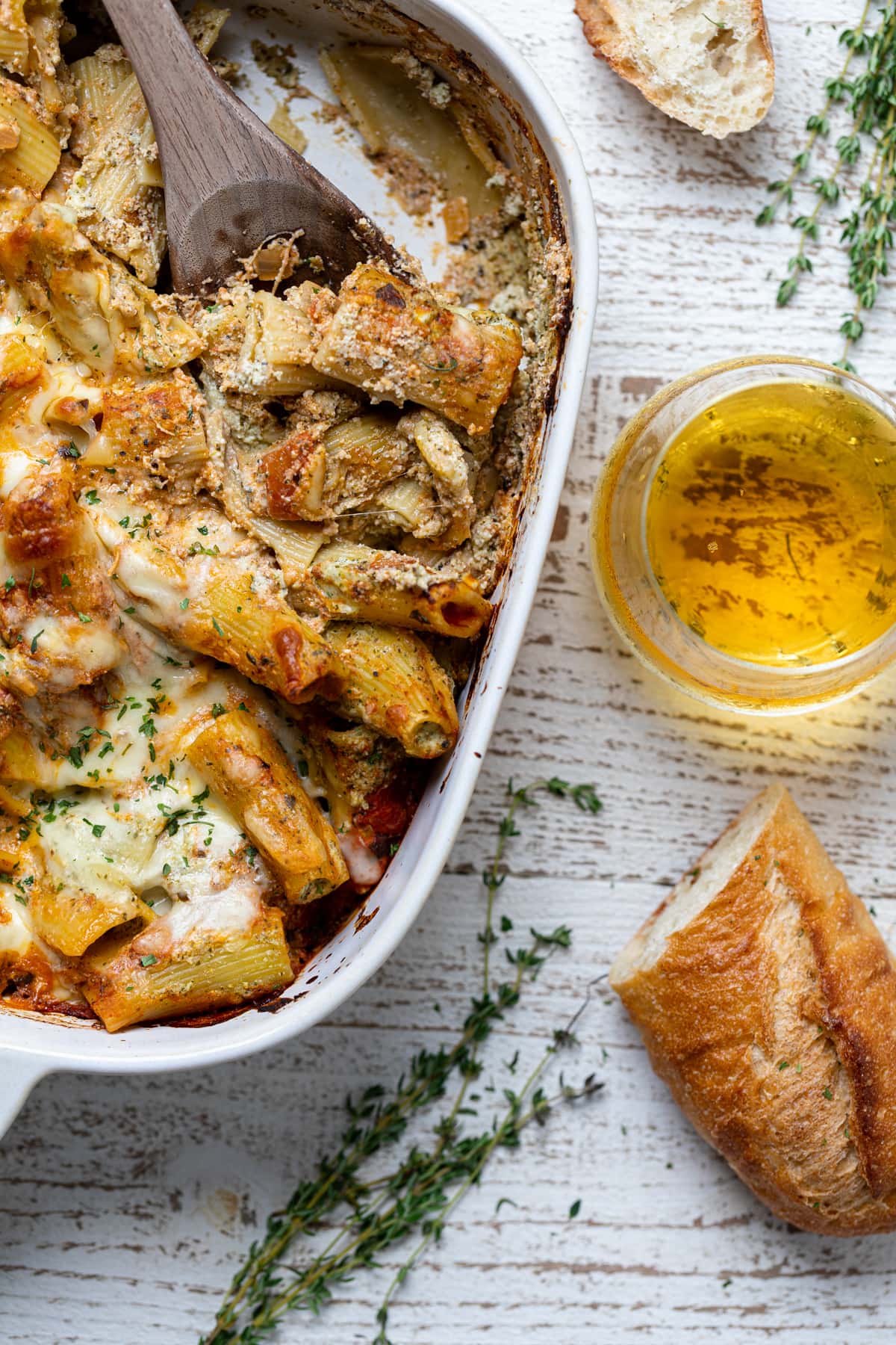 Partially-served baking pan of Pesto Pasta with Ricotta next to bread