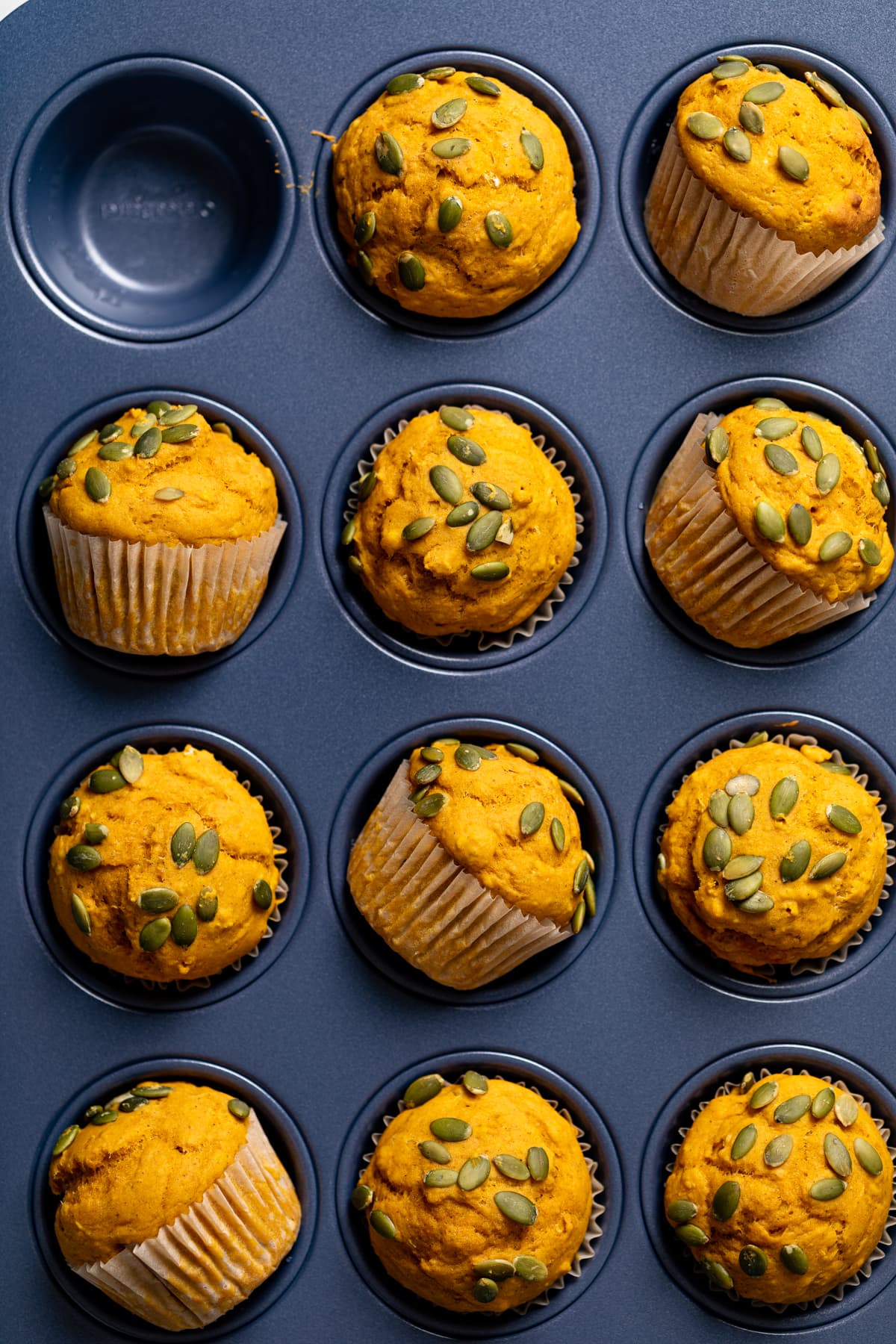 Vegan Pumpkin Spice Muffins in a muffin pan with some askew