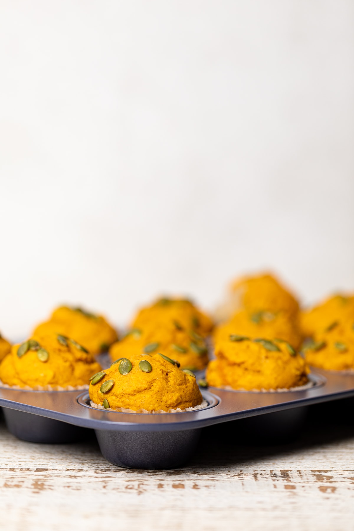 Side view of Vegan Pumpkin Spice Muffins in a muffin pan