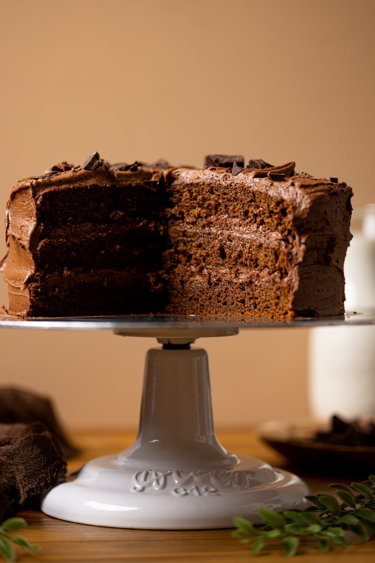 Vegan Chocolate Cake on a decorative serving display missing a slice