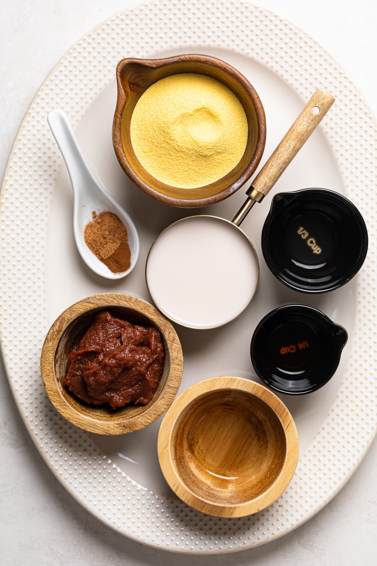 Ingredients for Apple Spice Cornmeal Waffles including cornmeal, apple butter, and almond milk