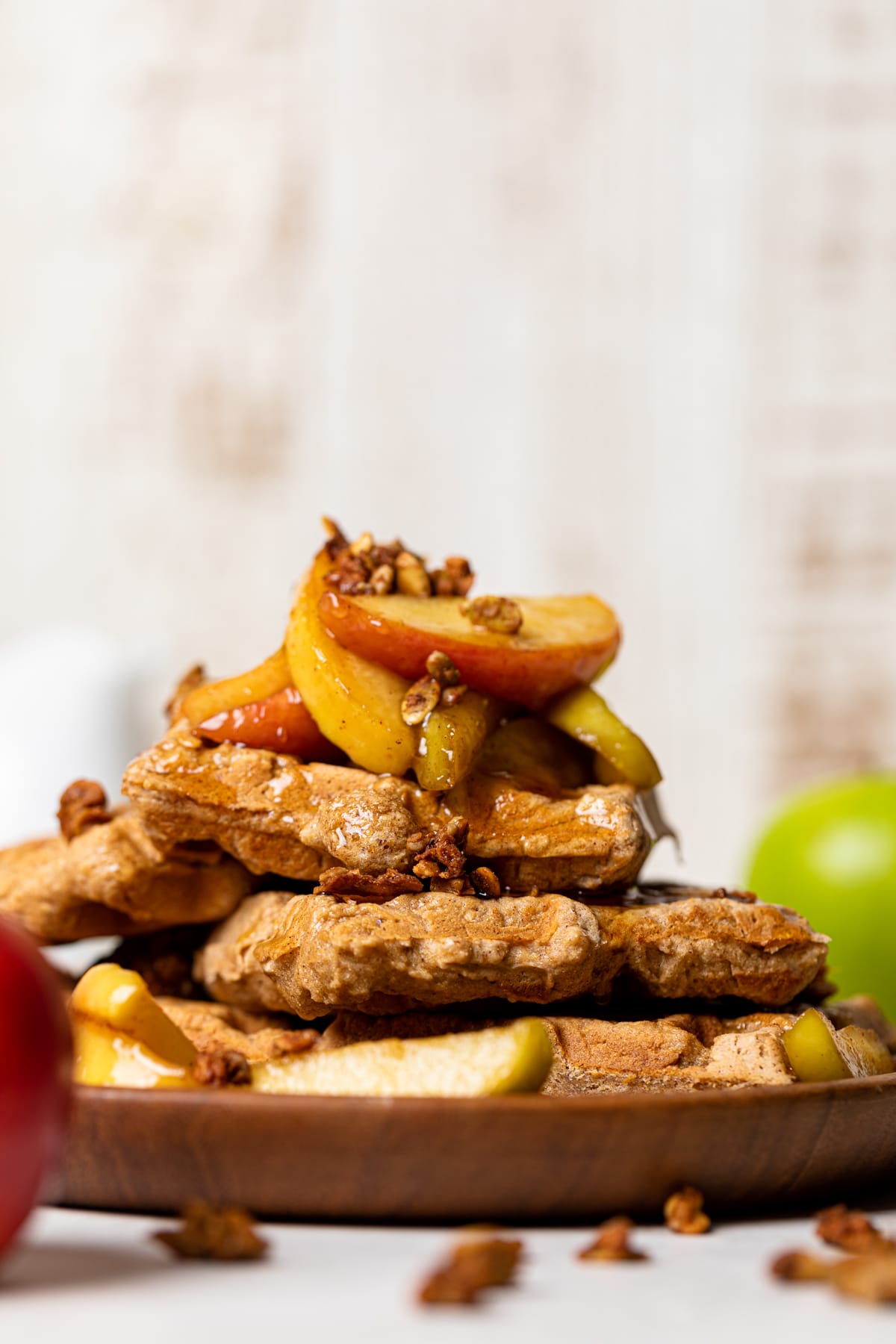 Closeup of Apple Spice Cornmeal Waffles topped with caramelized apples and granola