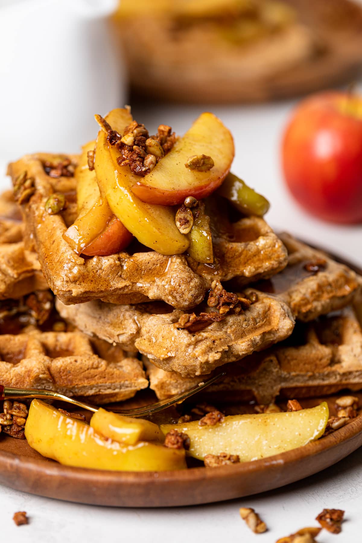 Closeup of Apple Spice Cornmeal Waffles topped with caramelized apples and granola