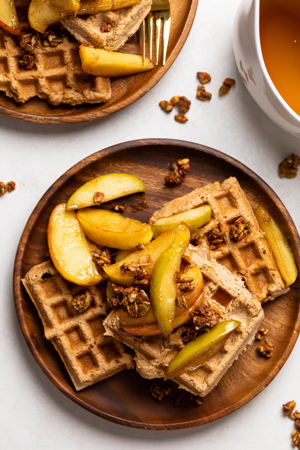 Overhead shot of Apple Spice Cornmeal Waffles topped with caramelized apples and granola