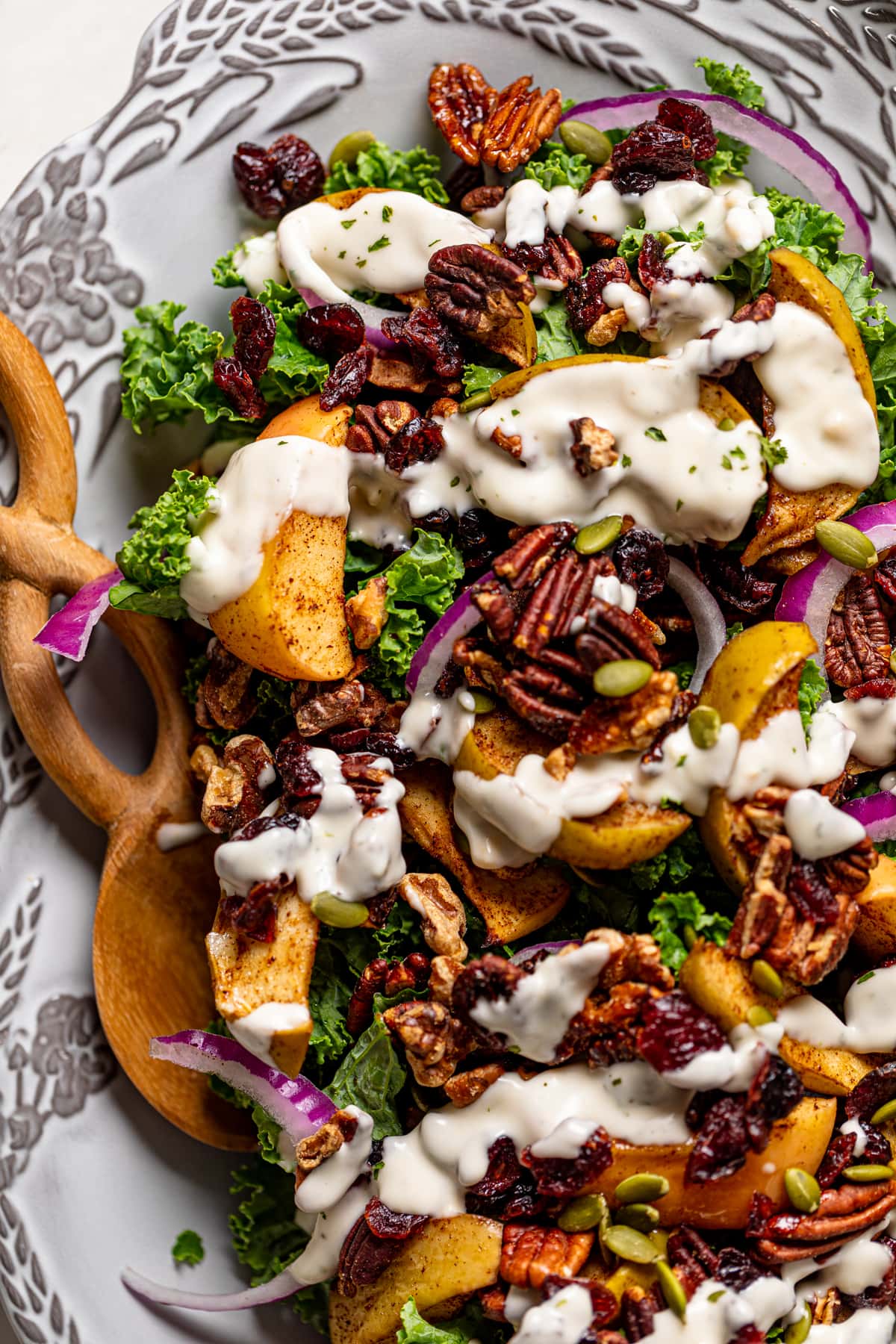 Closeup of Fall Harvest Kale Salad drizzled with dairy-free lemon-garlic dressing